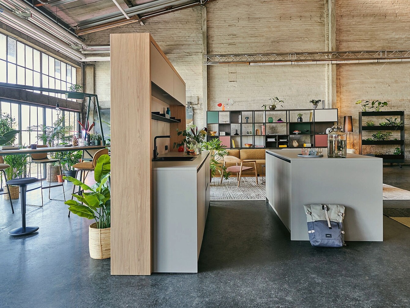 Modern se:café bar interior, a central island, open shelving with plants and decor, and large industrial windows